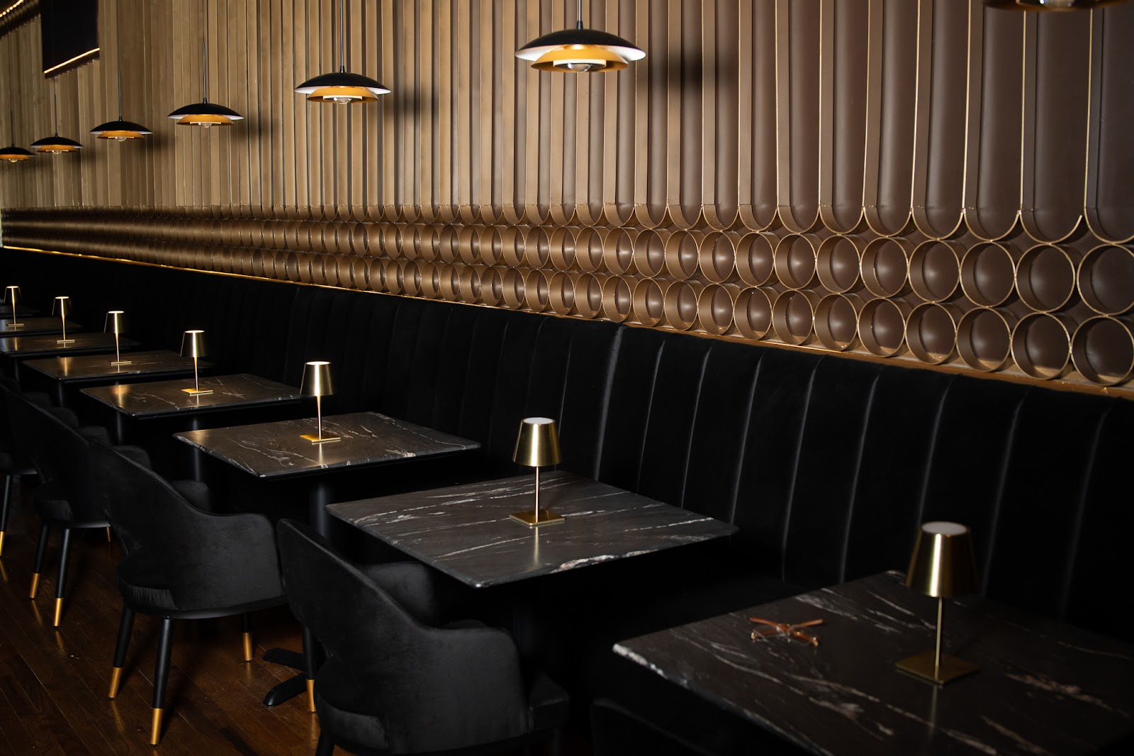 AURA dining room with brass lighting and polished seating