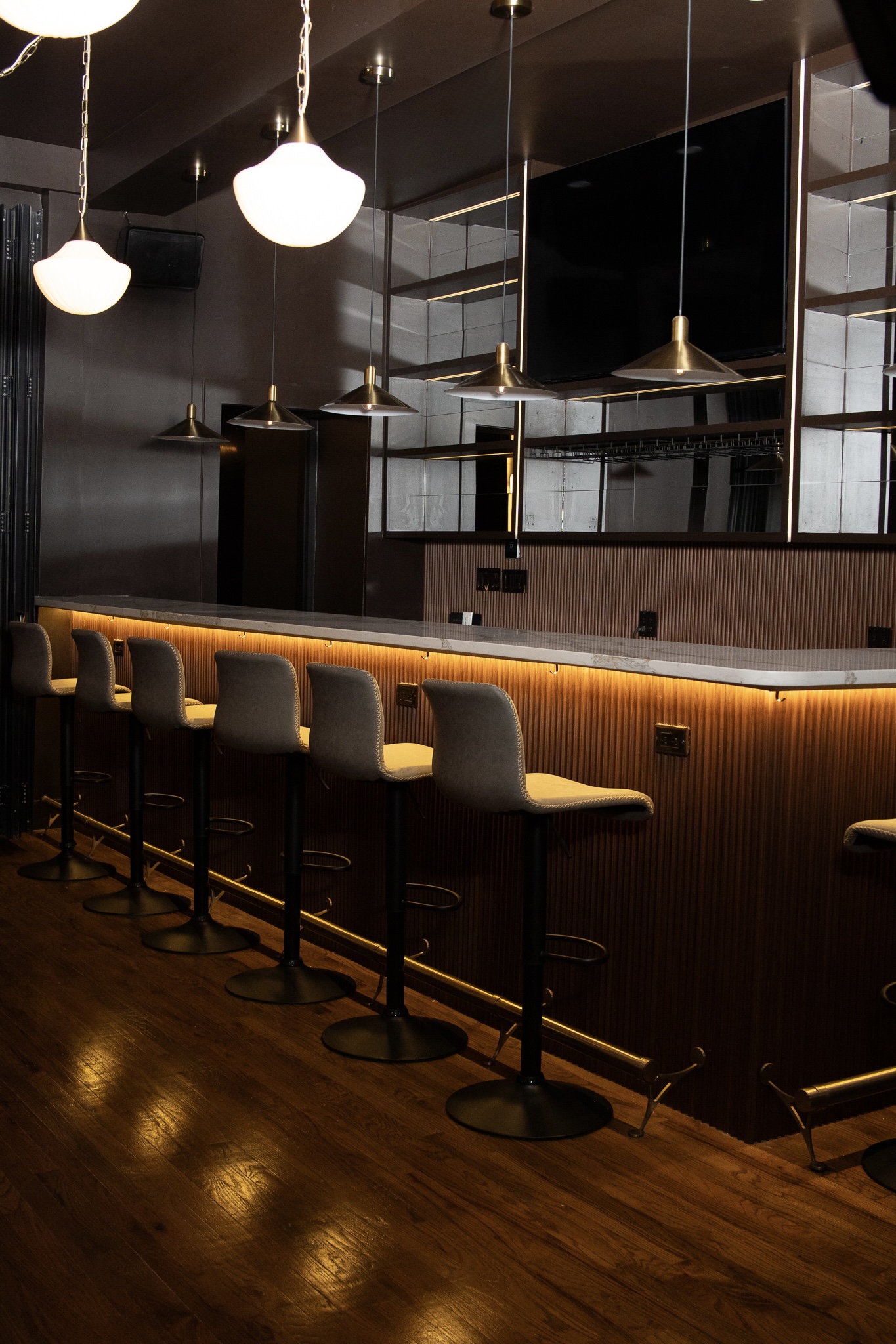 AURA bar seating with warm pendant lighting